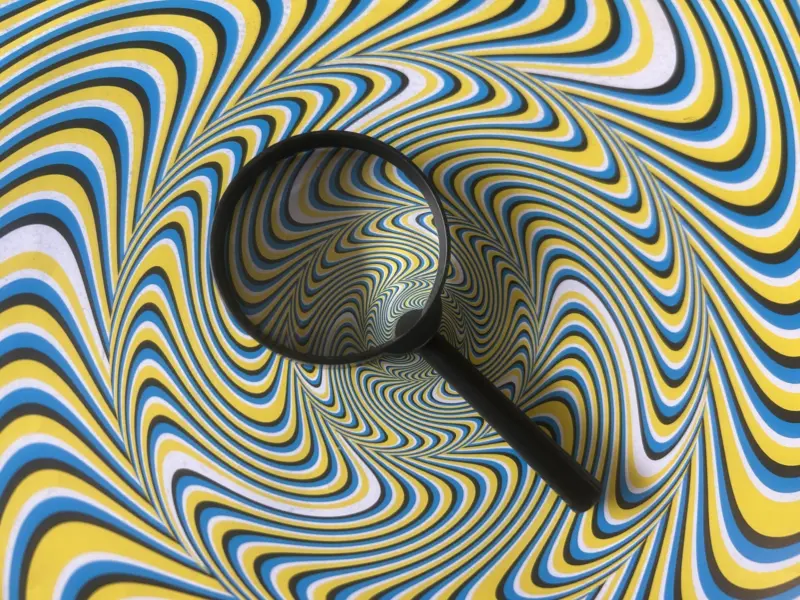 A magnifying glass sits on a colourful wavy background