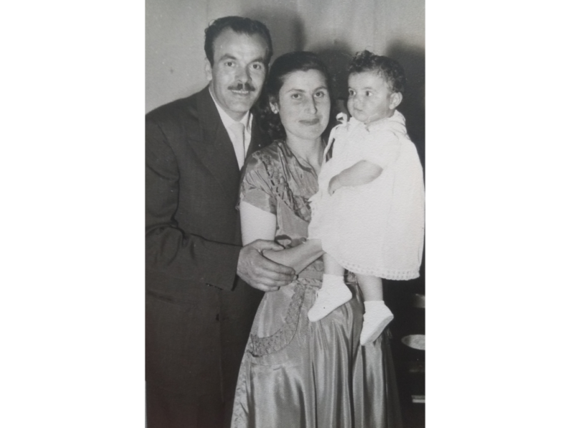 Black-and-white photograph of a moustachioed man with a woman who is holding a baby. The man and woman are dressed formally and are smiling at the camera, while the baby is looking off to one side.