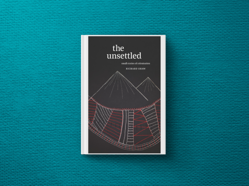 Black and white book cover of The Unsettled by Richard Shaw. Line drawing in white and red of mountains and a cloak underneath.