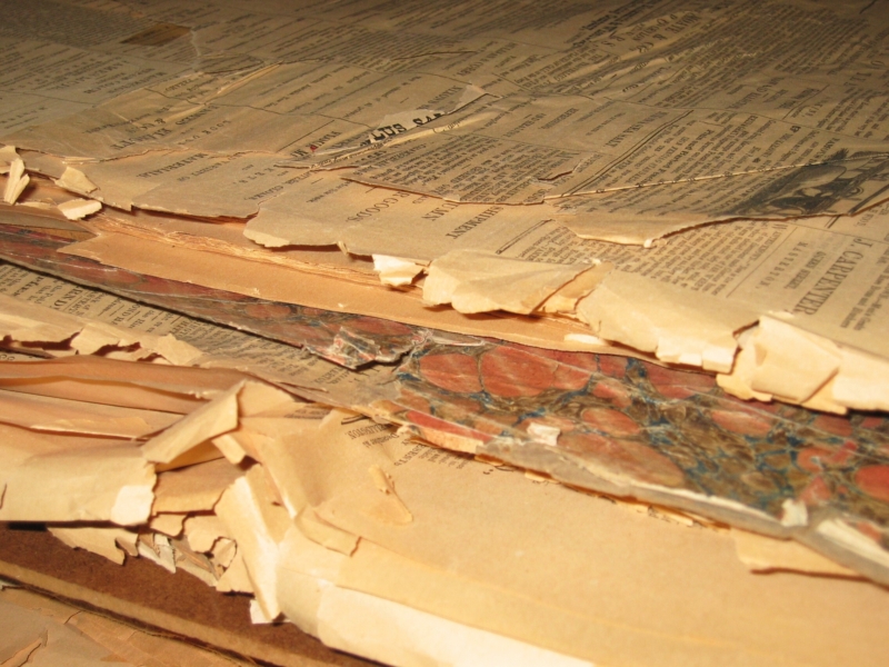 Photo of bound pages with marbling edge work. Some of the pages are curled, yellow, brittle and breaking at the edges due to age.