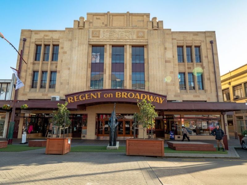 Large yellow stone building with maroon awning that says "Regent on Broadway".